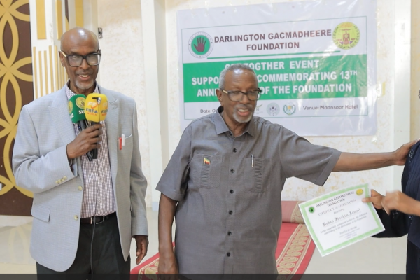 Professor Eid Ali Ahmed and Vice President Awli look on as a proud recipient displays her certificate
